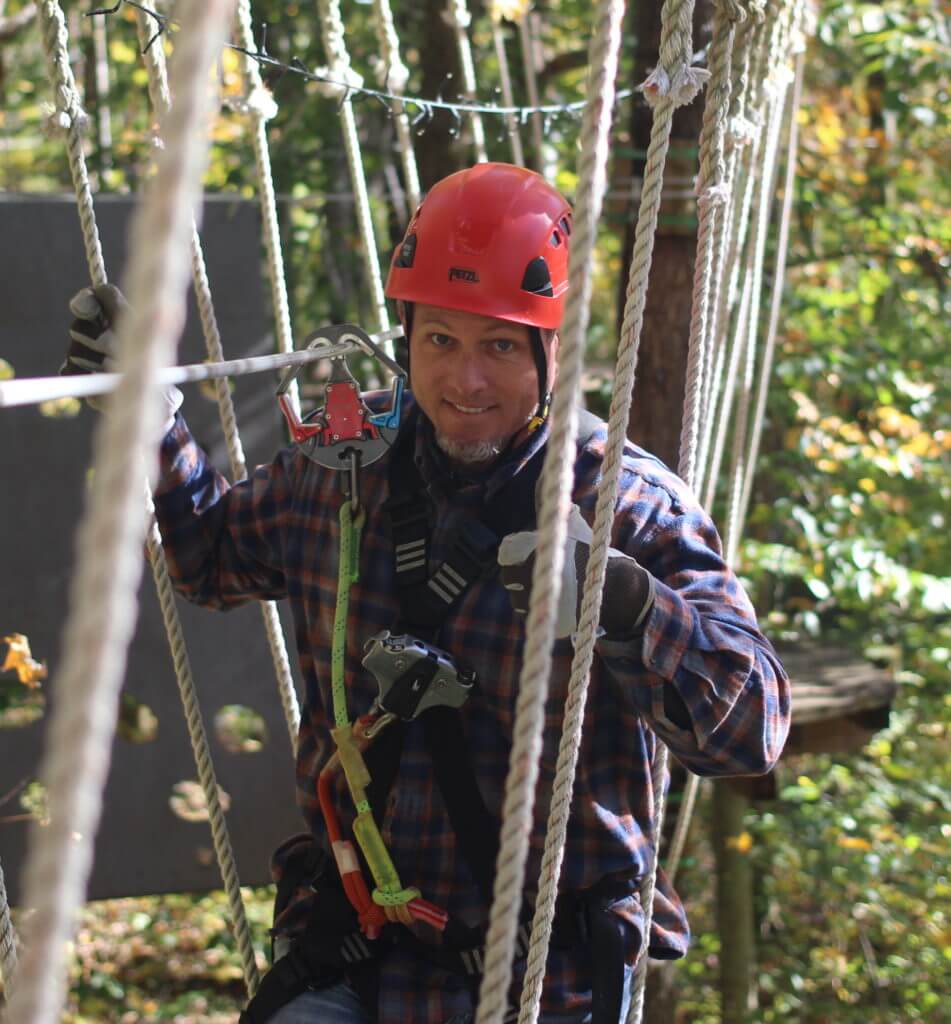 Man crossing bridge on adventure park